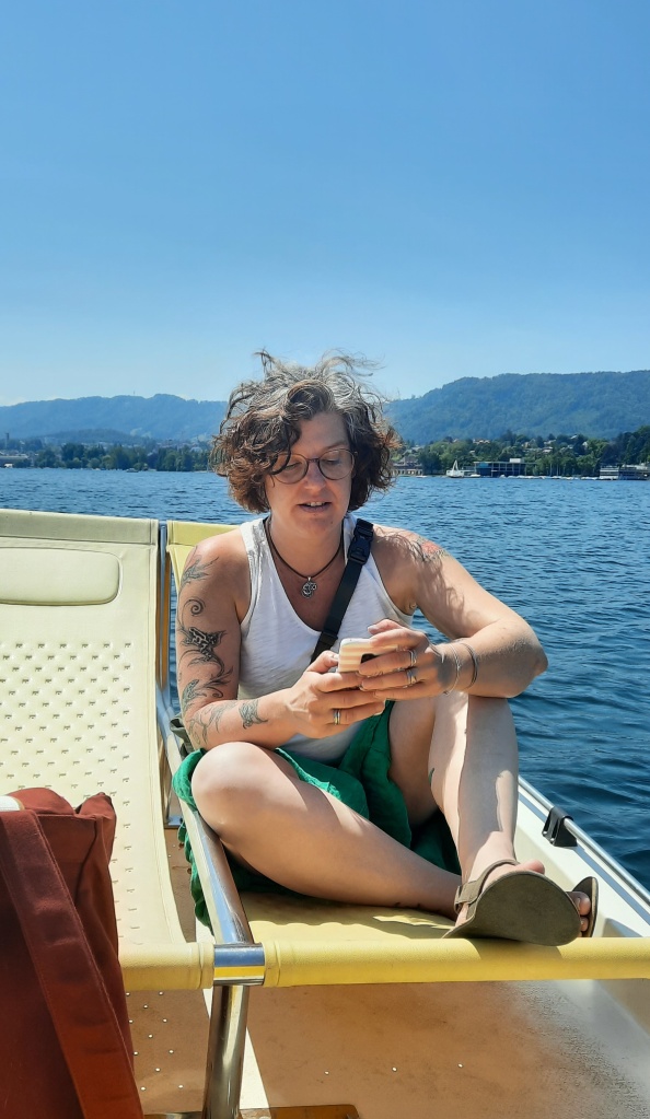 Eine Frau, die auf einem Tretboot sitzt und auf ihr Handy schaut